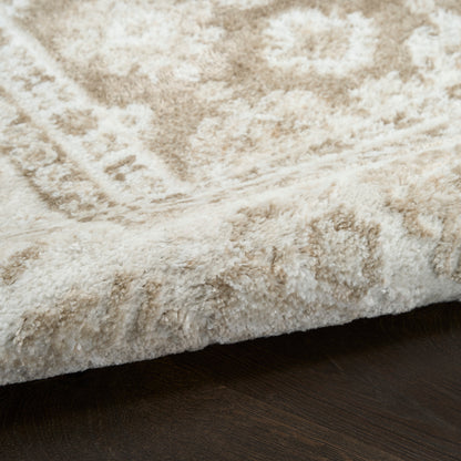 Cream shag rug with subtle beige pattern, plush pile and rolled edge on dark wood floor.