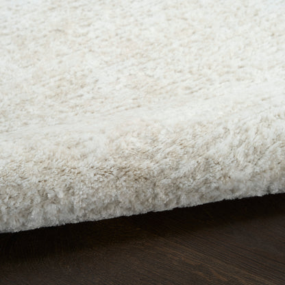 Cream shag rug with fluffy plush pile resting on dark wooden floor.