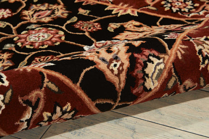 Persian-style rug with deep burgundy and black background, ornate floral pattern, plush pile, resting on wooden floor