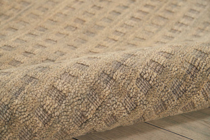 Beige patterned area rug with plush tufted pile and subtle geometric diamond motif on wooden floor.