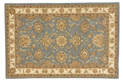 Rectangular blue Persian-style area rug with cream-gold floral motif and a beige border.