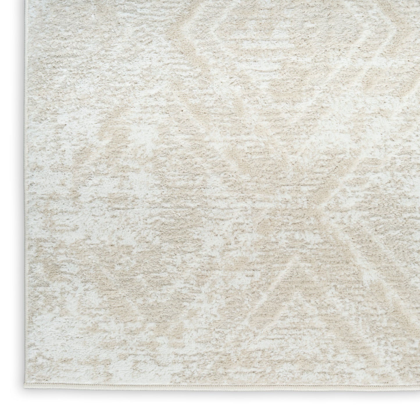Cream textured rug with plush pile and subtle geometric diamond pattern, bound edge.