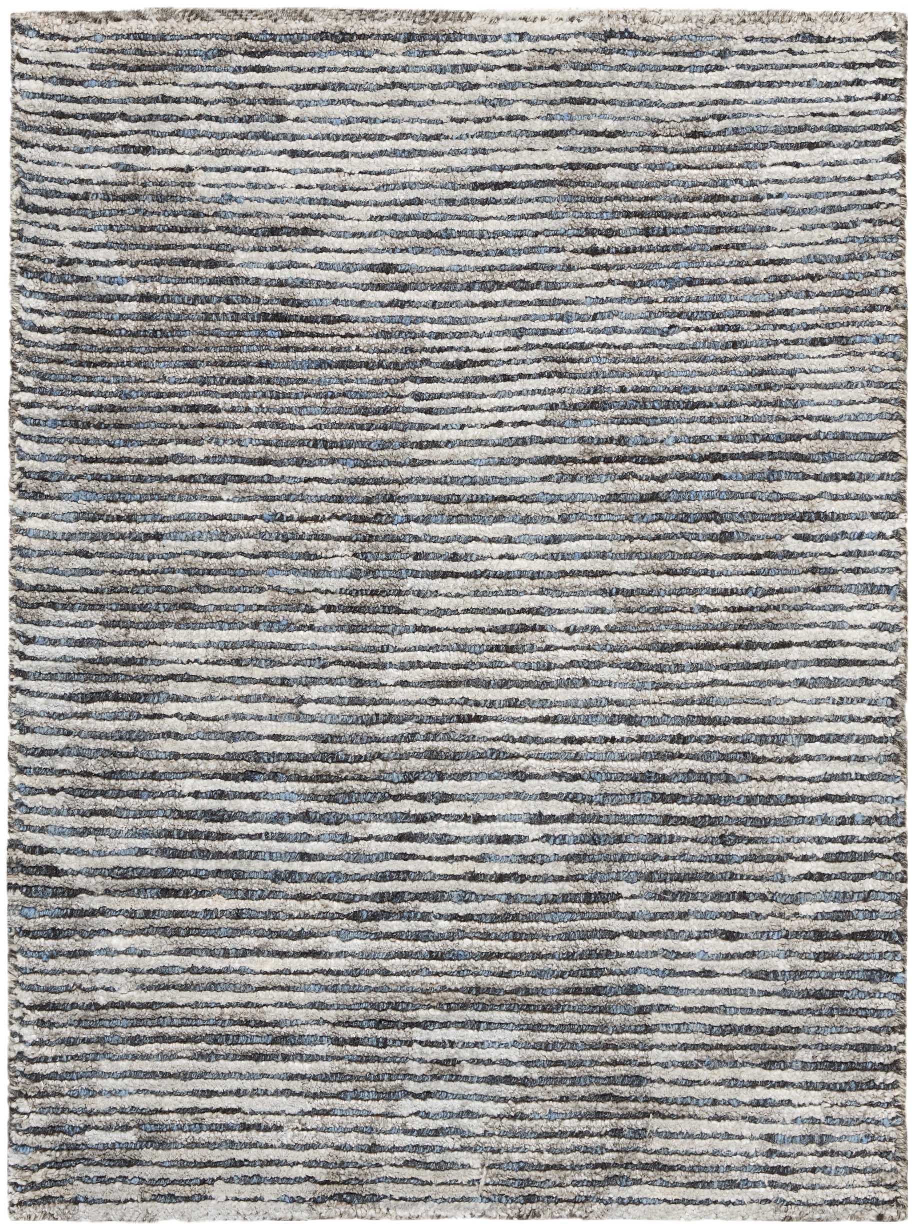 Rectangular rug with irregular blue-gray stripes on a cream background; textured, modern, neutral-toned.