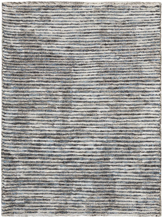 Rectangular rug with irregular blue-gray stripes on a cream background; textured, modern, neutral-toned.