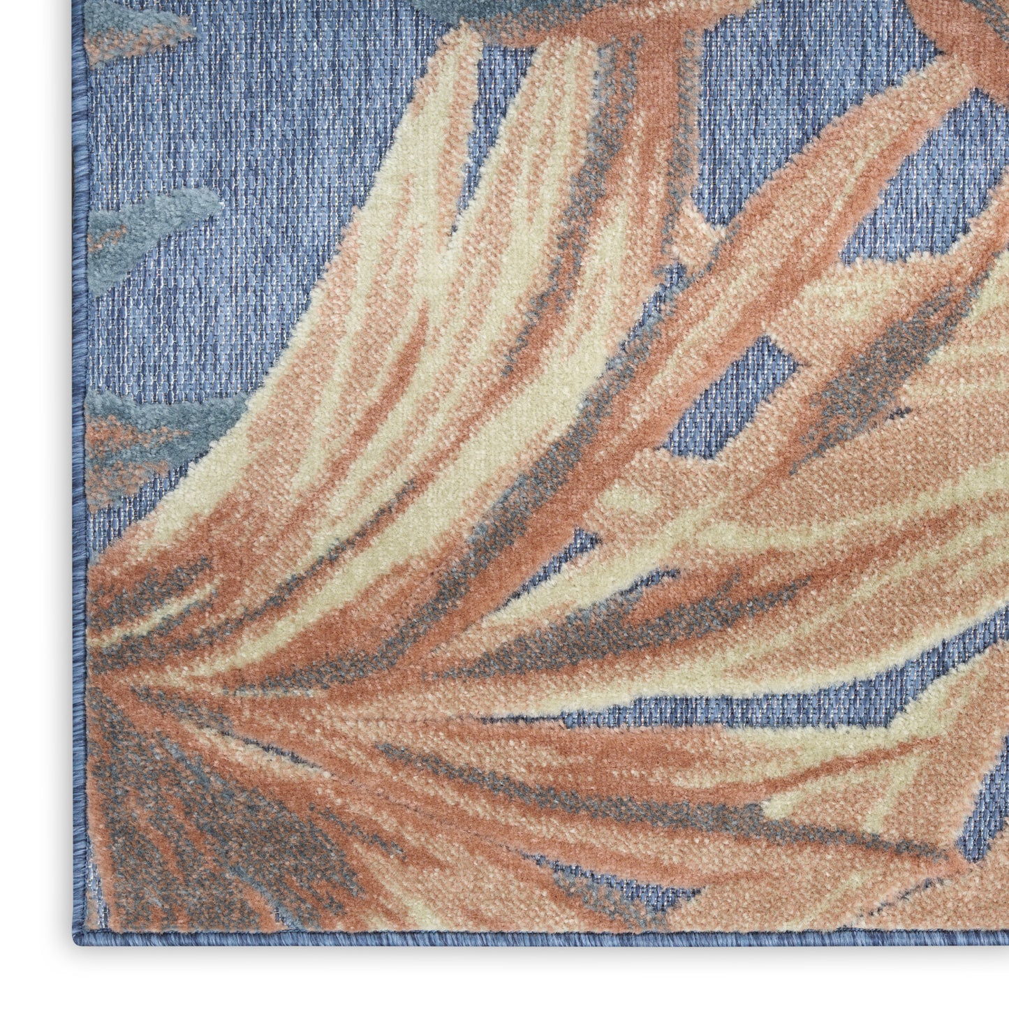 Woven area rug featuring peach and cream palm leaf design on blue background with a blue border.