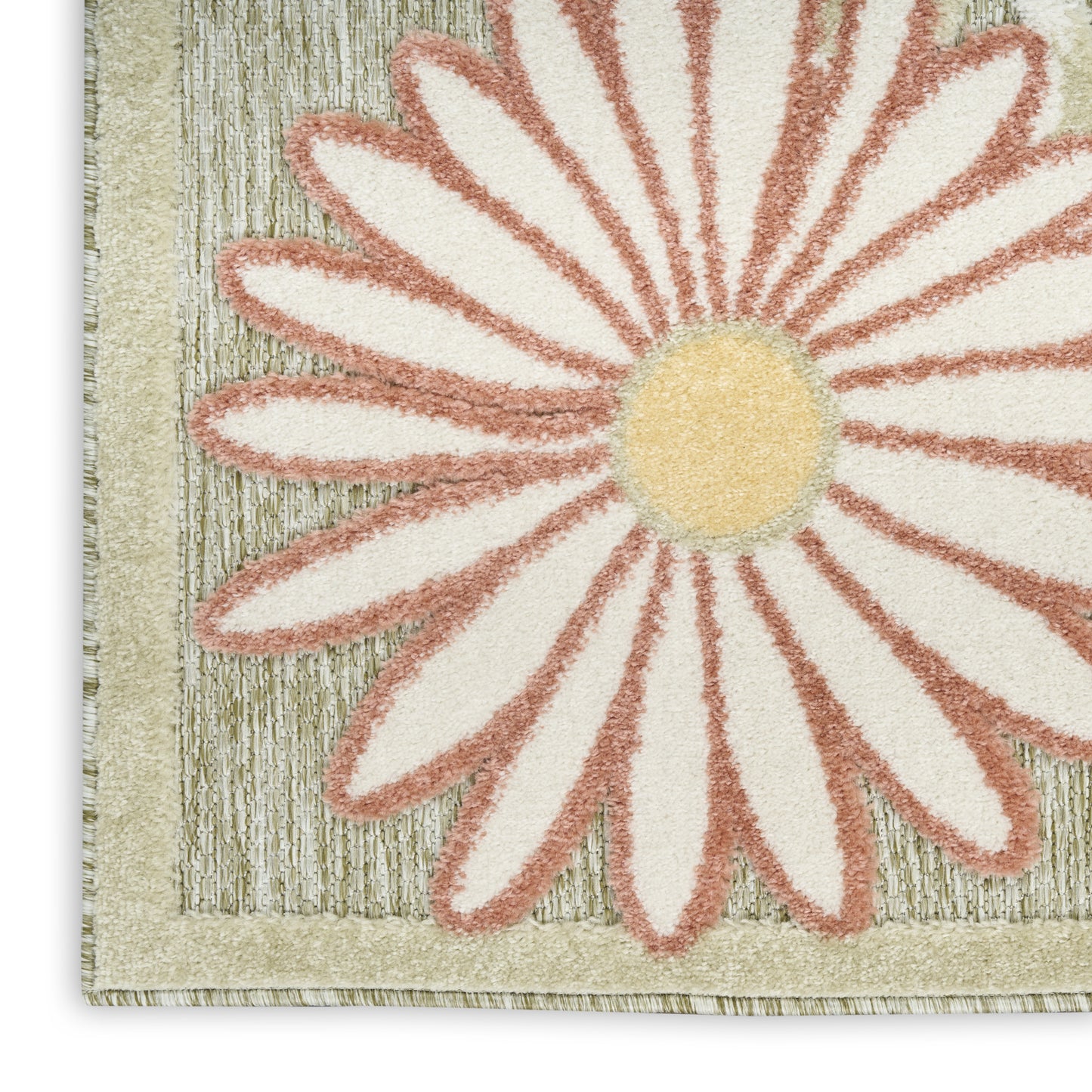 Close-up of a tufted rug with a large pink-peach daisy, cream petals, yellow center, and textured sage border.