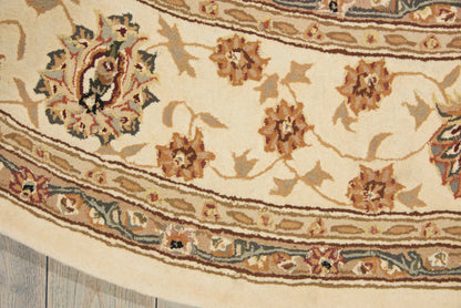 Close-up of cream oriental rug with brown and tan floral motifs and blue border detailing.