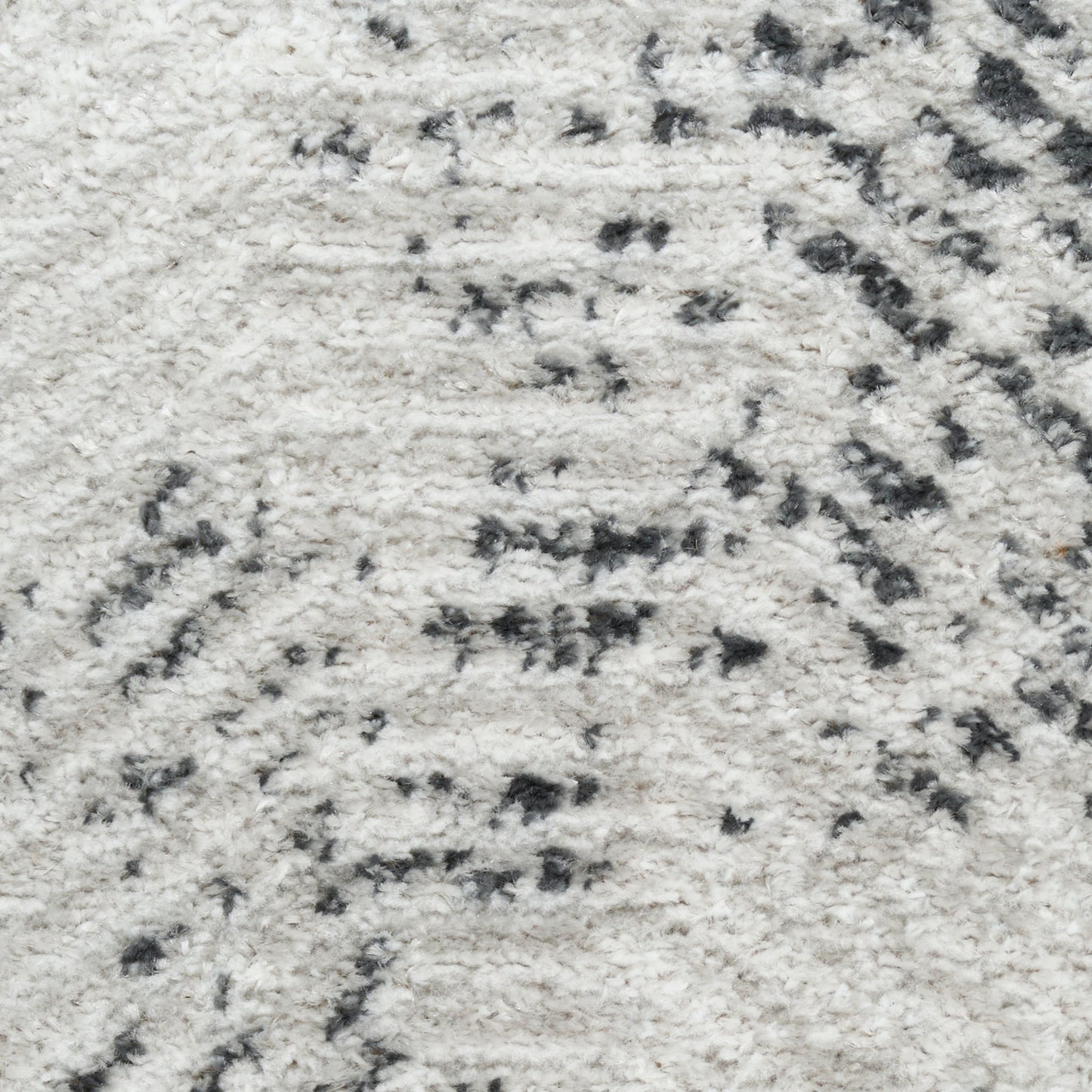 Close-up of cream shag rug with subtle dark gray abstract pattern, plush soft pile.