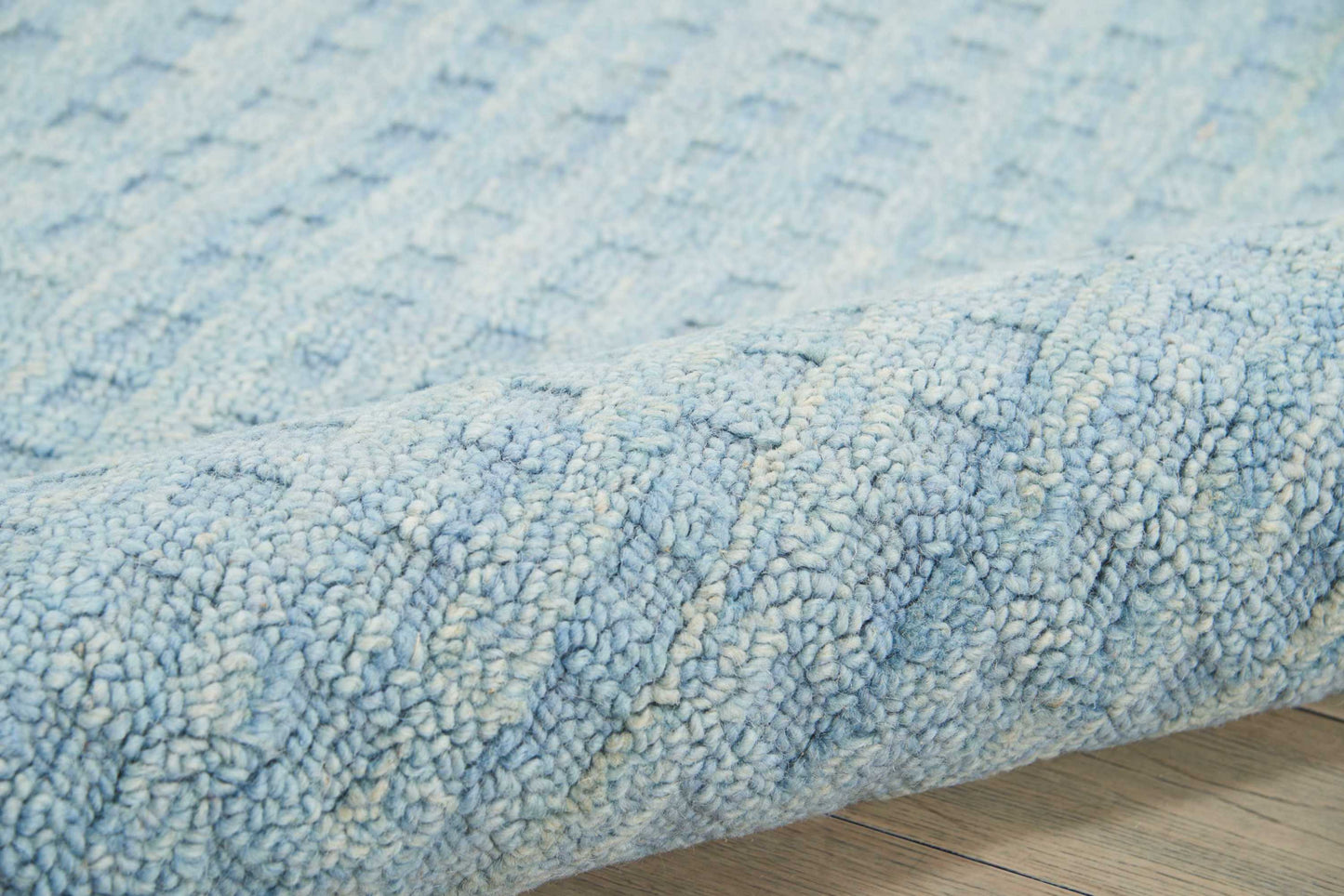 Blue textured boucle shag rug with thick loop-pile and ivory flecks; soft, cozy living room decor.