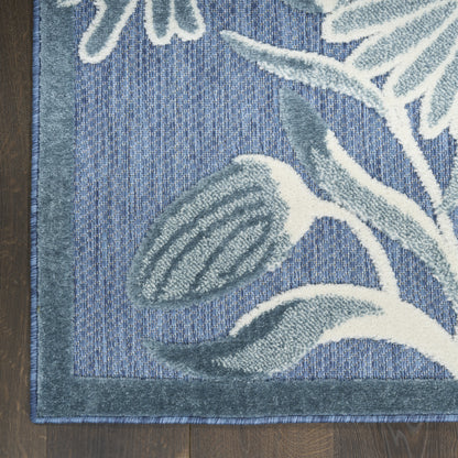 Blue botanical woven outdoor area rug with pale gray-blue leaf motif and dark blue border.