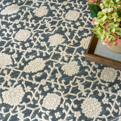 Navy rug with cream floral lattice pattern; wooden tray with pink-green hydrangea blossoms.