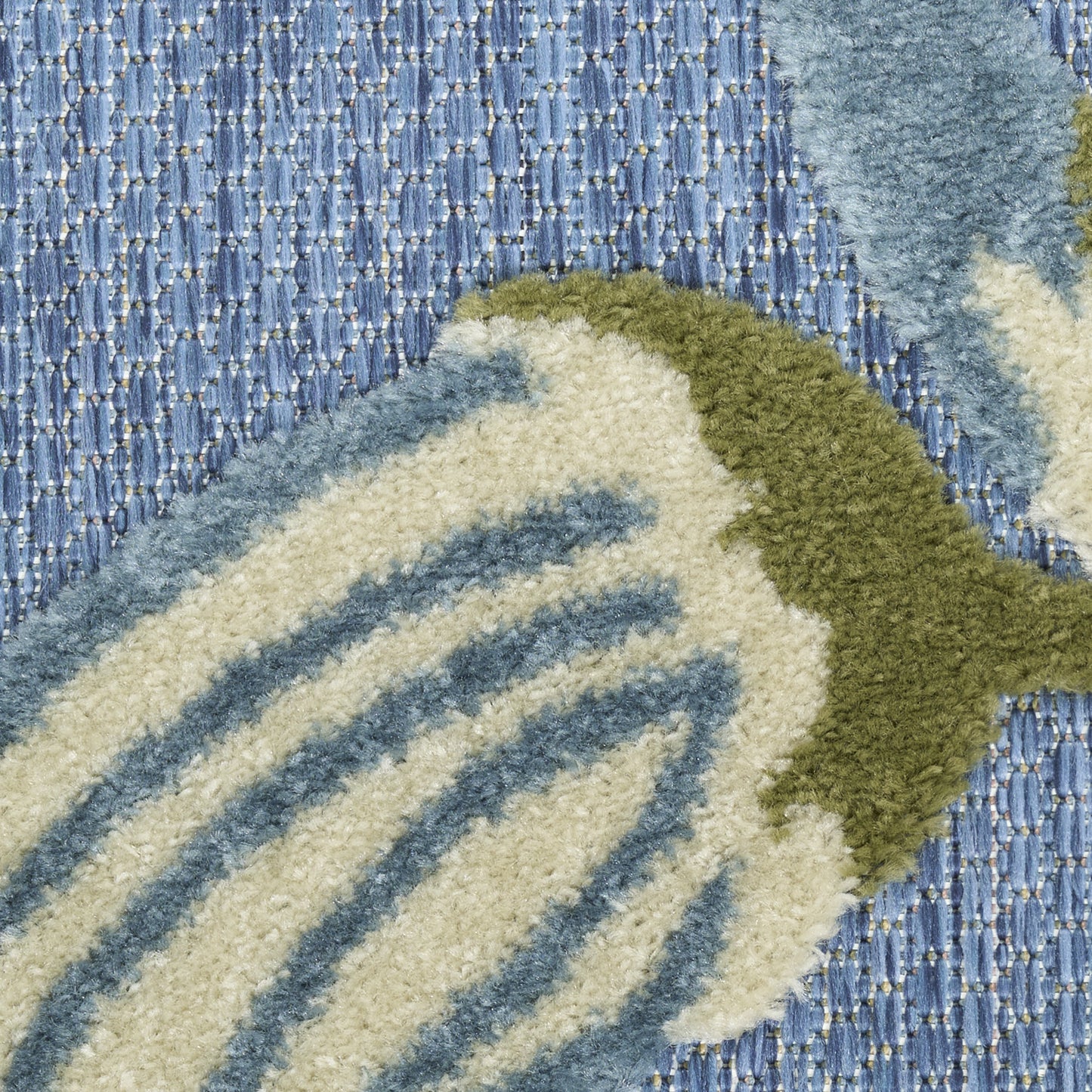 Soft blue tufted rug with cream and blue striped leaf motif outlined in olive green.