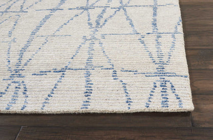 Rectangular cream rug with light blue geometric lines, woven low-pile textile on dark wood floor.