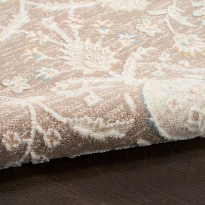Beige floral area rug with white pile and pale blue accents, rolled edge on dark wooden floor.