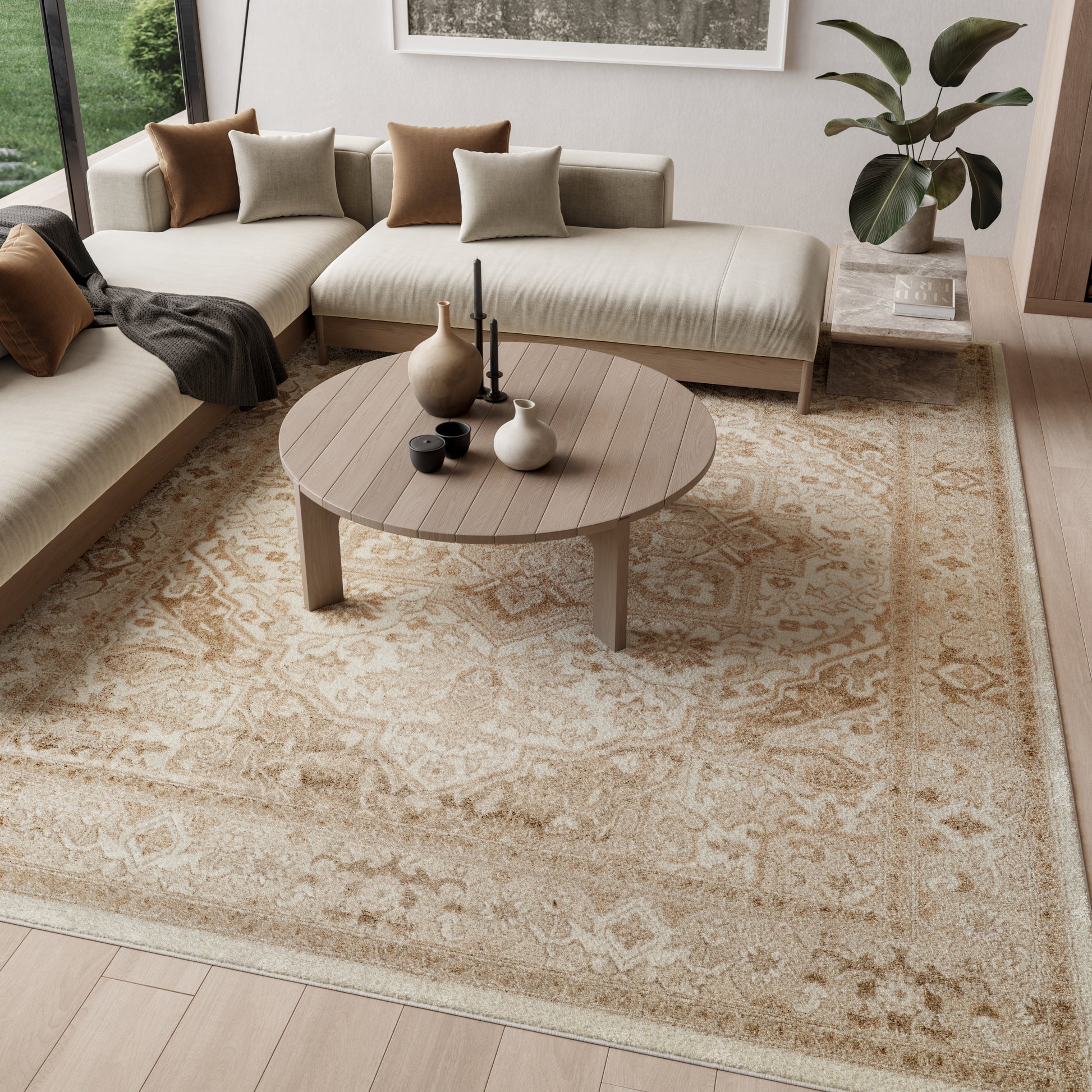 Round wooden coffee table with vases and candles, beige sectional sofa, and patterned beige rug in a modern cozy living room.