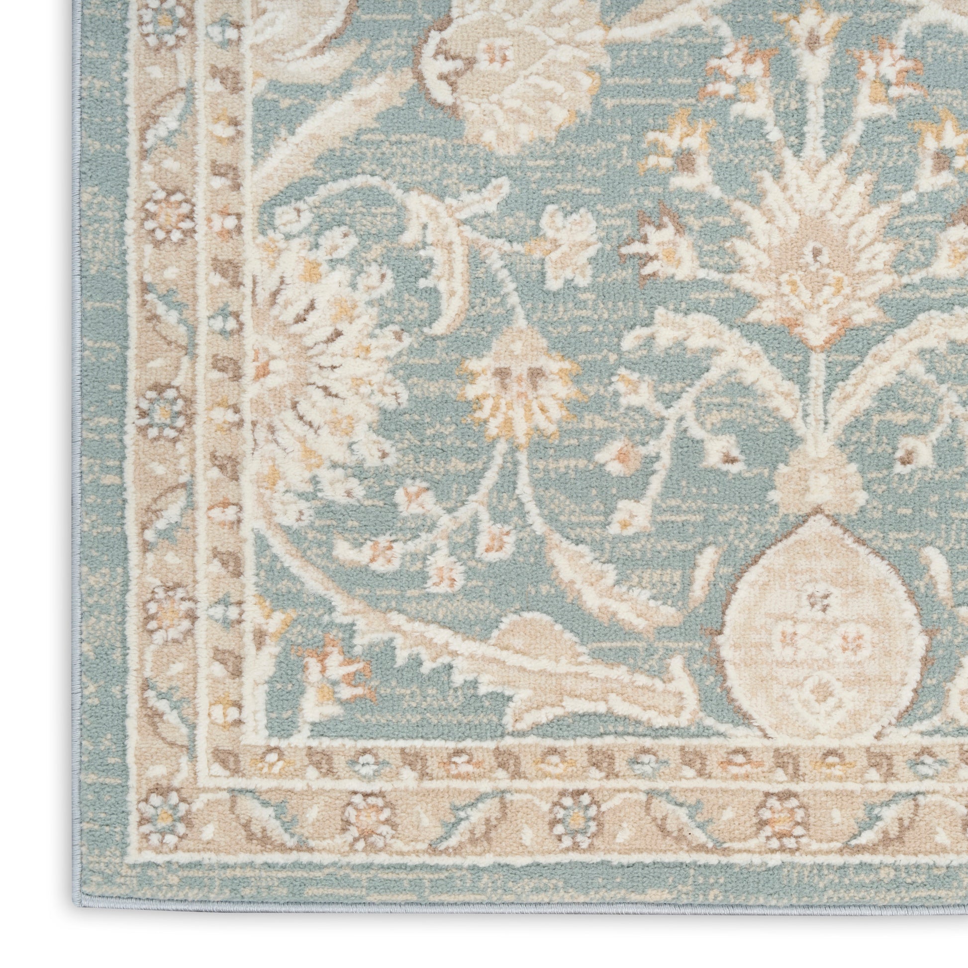 Teal blue woven oriental rug corner with ivory floral damask pattern and beige border.