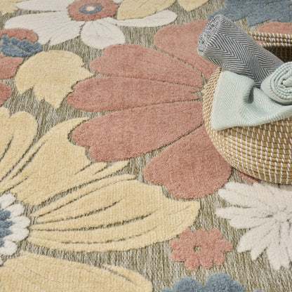 Pastel floral area rug with pink, cream and yellow petals; wicker basket with folded blue chevron and mint towels.