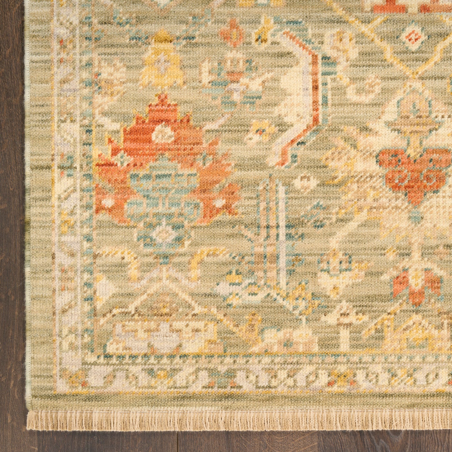 Traditional Persian-style area rug in beige, blue and coral with floral medallions and fringed edges.