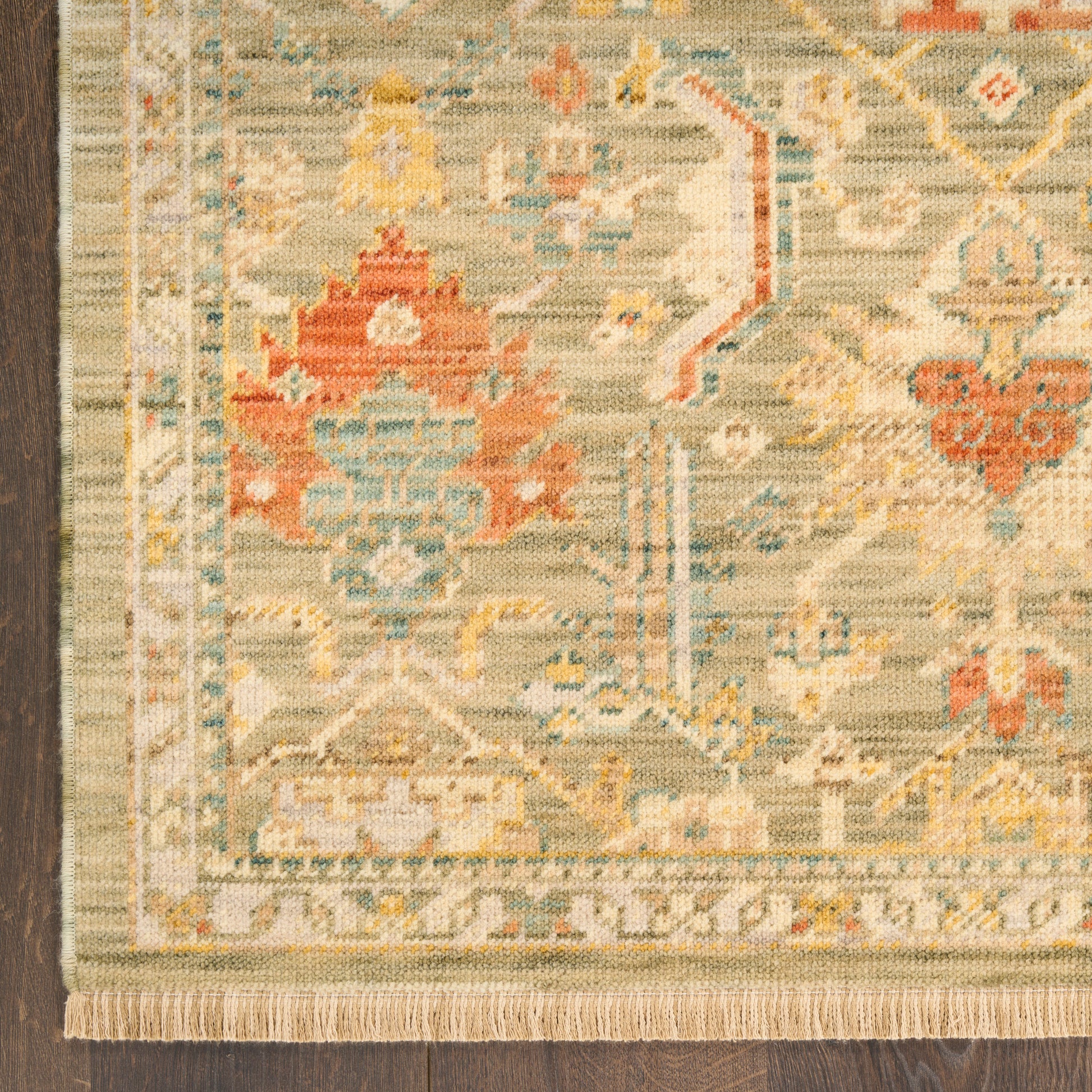 Traditional Persian-style area rug in beige, blue and coral with floral medallions and fringed edges.
