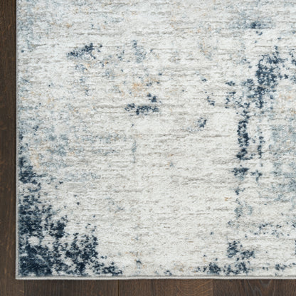 Cream and blue distressed area rug with abstract pattern on dark wood floor.