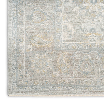 Distressed blue-gray oriental rug with beige floral patterns and ornate border, cropped corner.