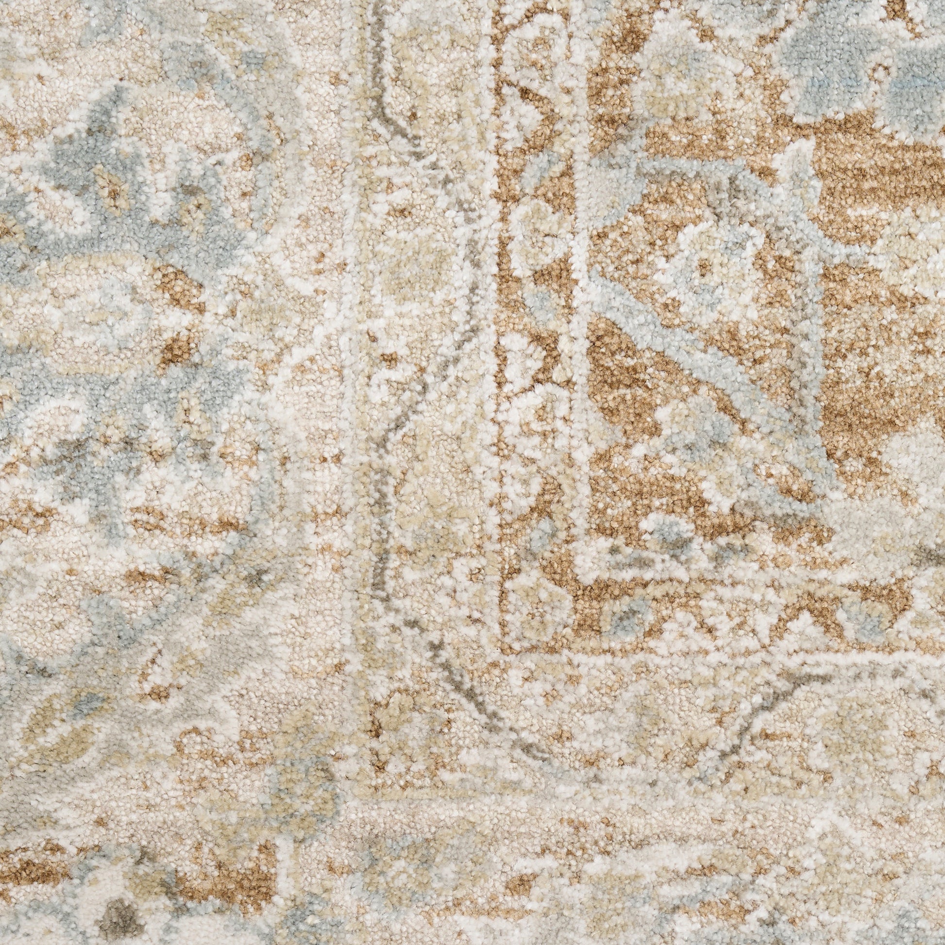 Distressed vintage rug in beige, light blue and tan with faded floral medallion, soft woven texture.