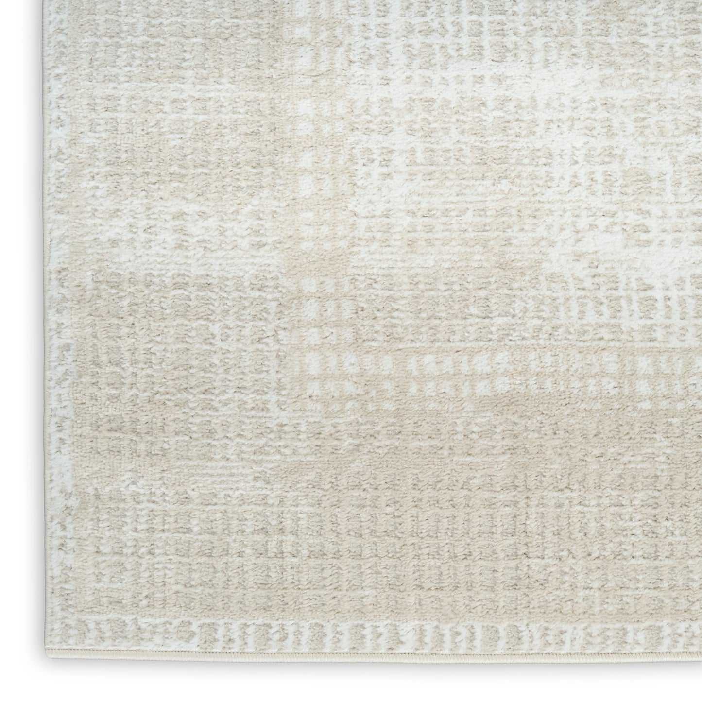 Cream-beige textured area rug close-up with subtle abstract pattern and light border.