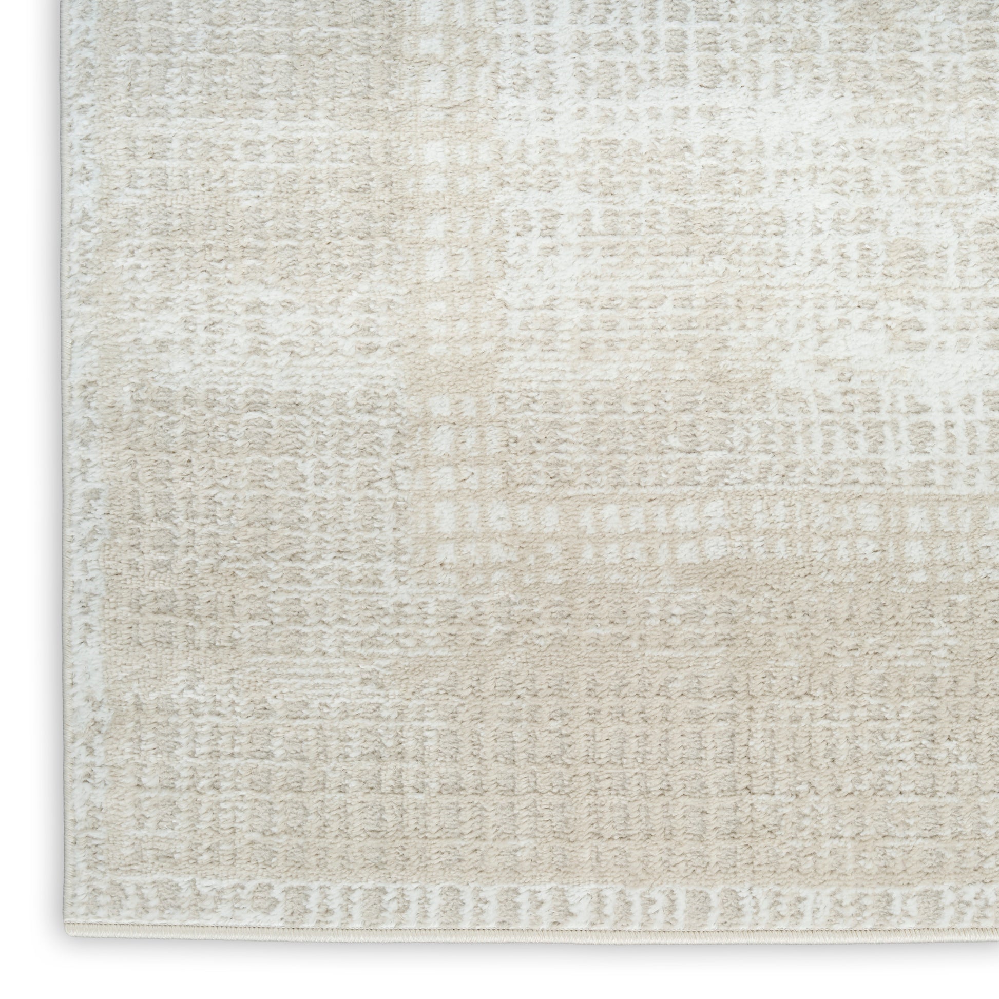 Cream-beige textured area rug close-up with subtle abstract pattern and light border.