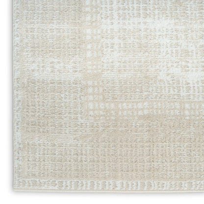 Cream-beige textured area rug close-up with subtle abstract pattern and light border.
