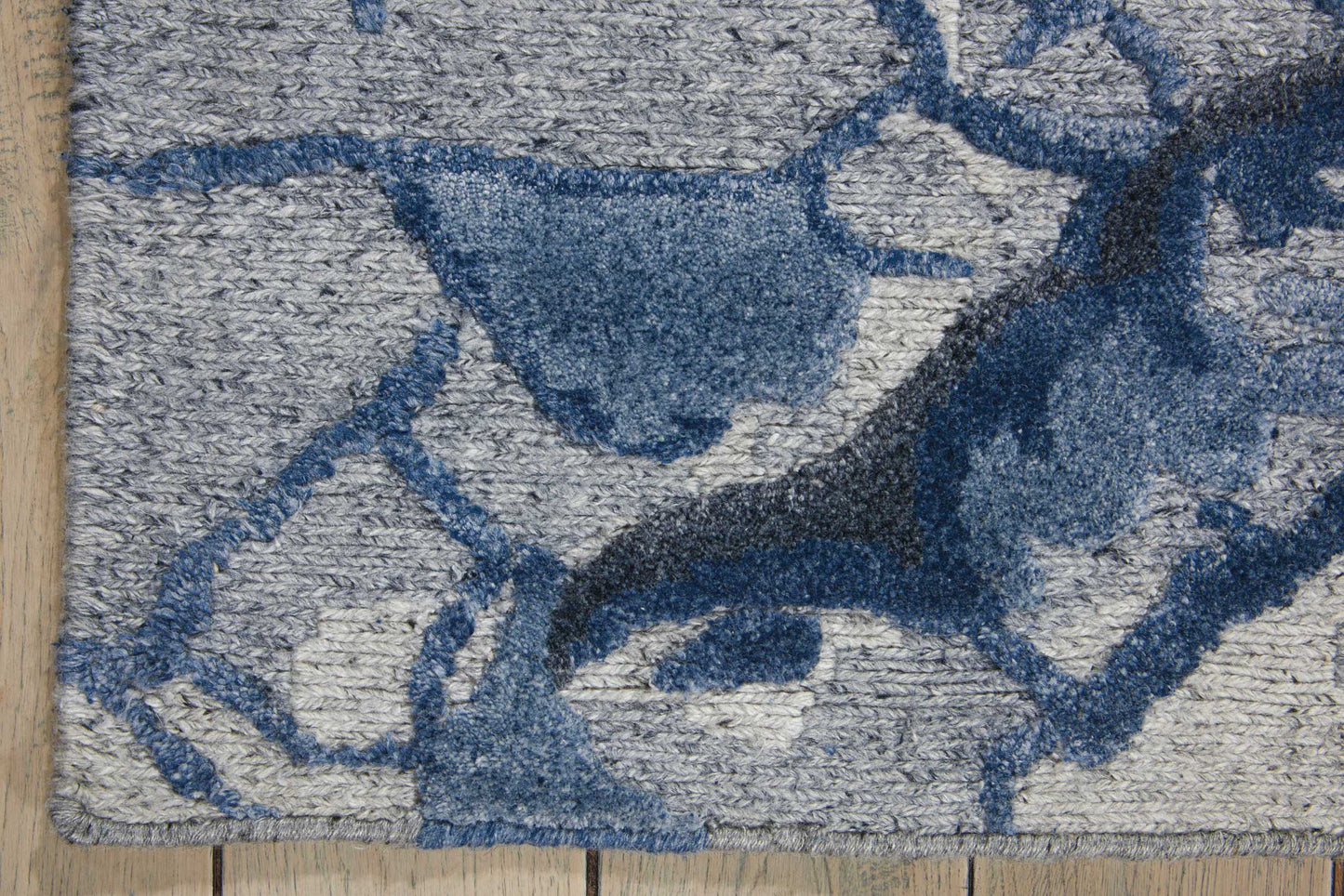 Abstract gray field rug with denim-blue shapes; plush tufted texture, rectangular area rug.