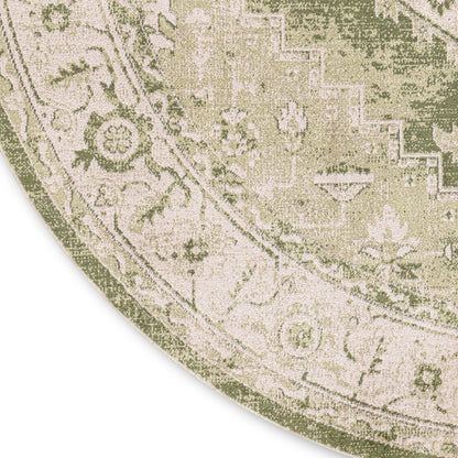 Round area rug with antique-style botanical pattern in muted green and cream.