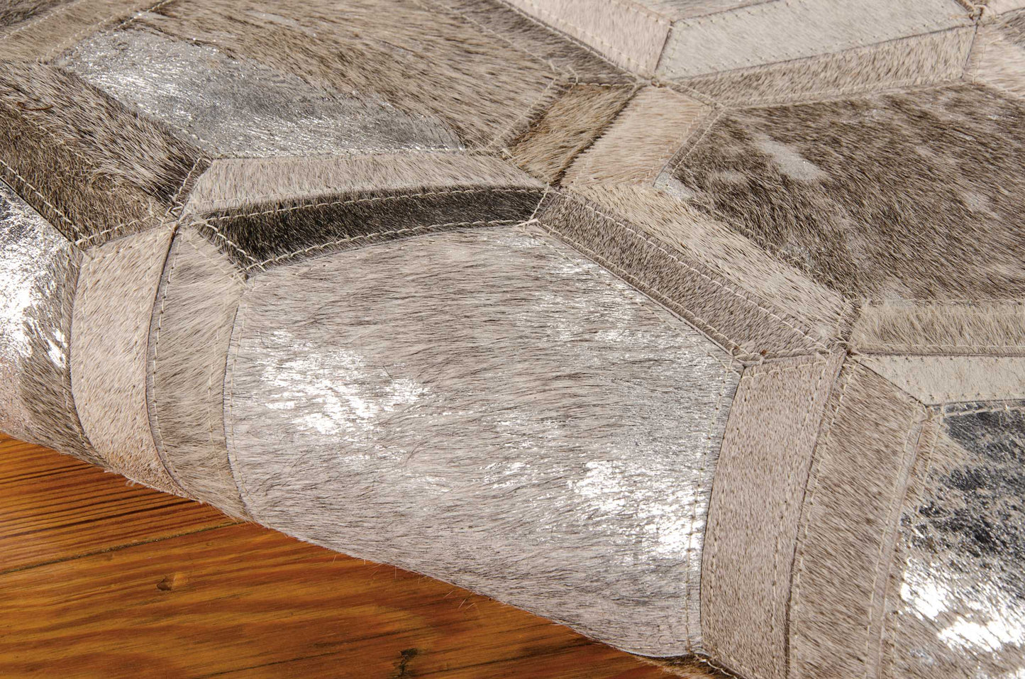 Hexagon-patch metallic faux leather ottoman in silver and taupe, geometric patchwork for living room decor.