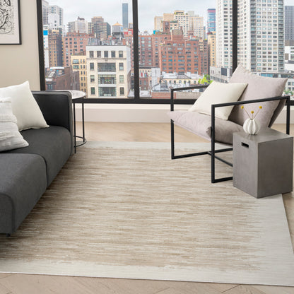 Modern living room with grey sofa, black metal-frame chair, beige striped rug, concrete side table with vase, skyline view.