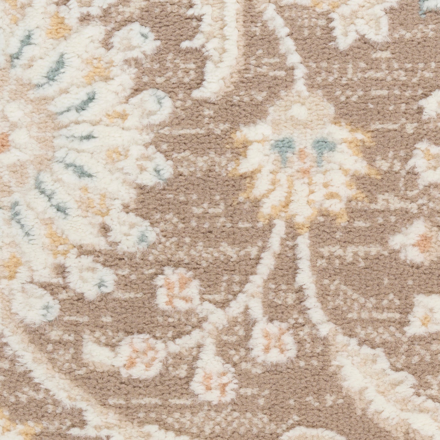 Beige-brown floral rug with cream, peach and pale blue accents; soft, textured woven style.