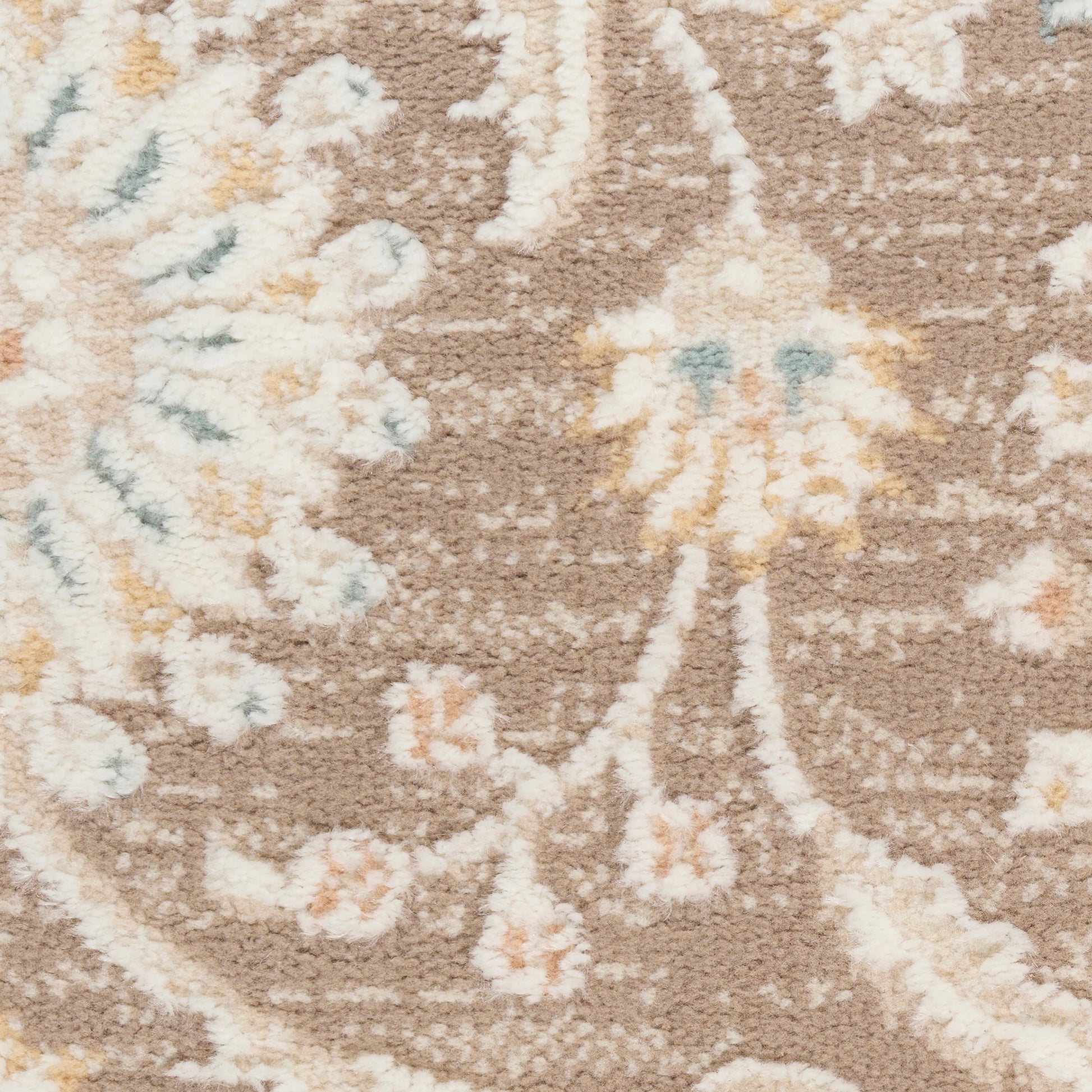 Beige-brown floral rug with cream, peach and pale blue accents; soft, textured woven style.