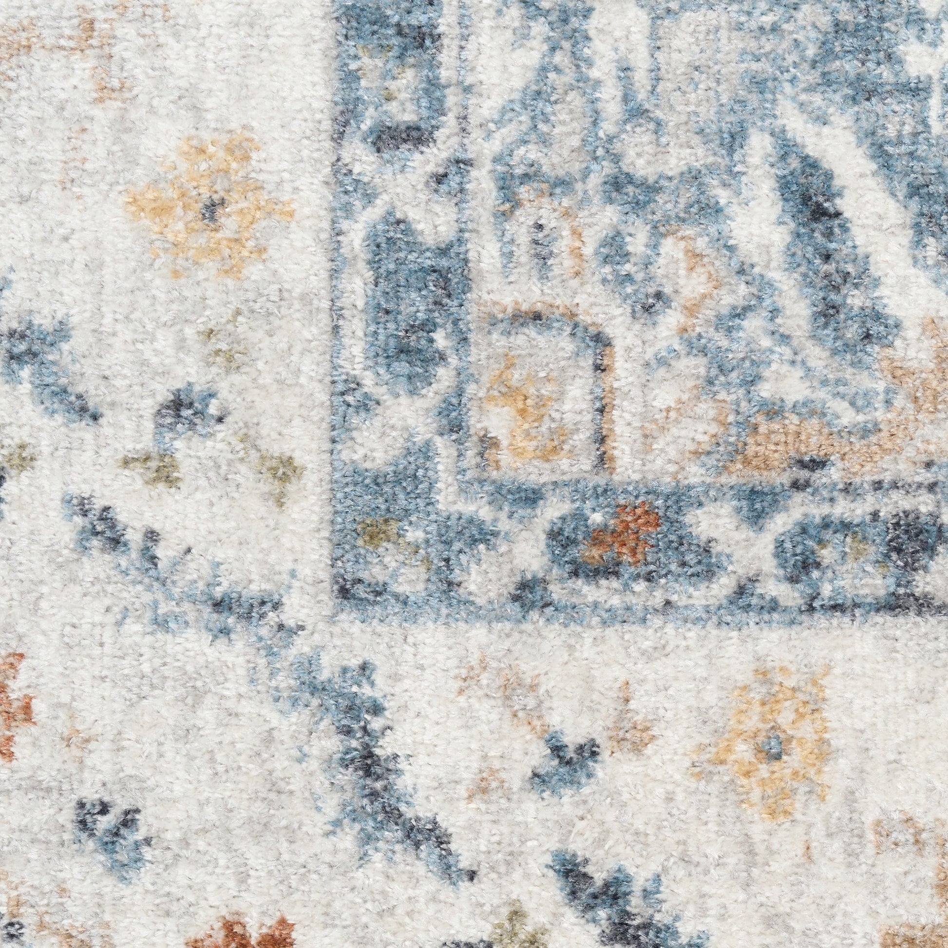 Distressed blue and ivory area rug with floral motifs and pale orange accents.