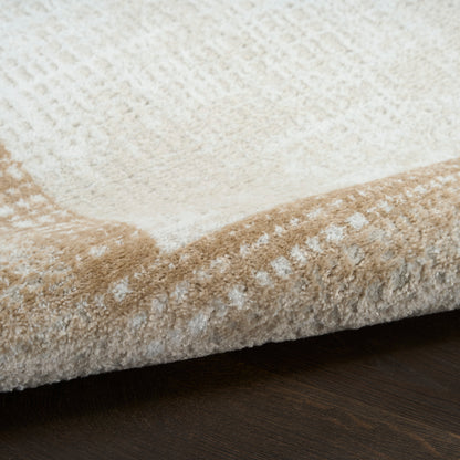 Beige and cream plush area rug with a soft pile and folded edge, placed on a dark wood floor.